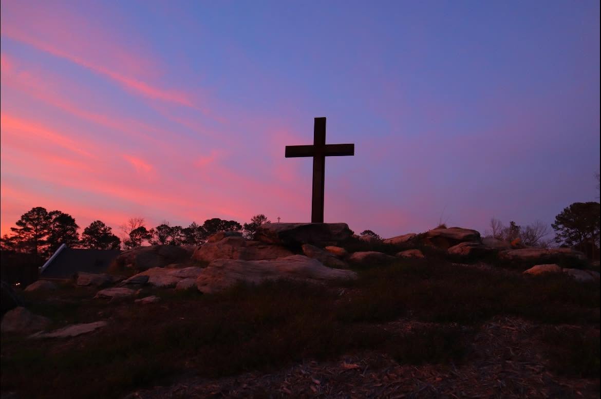 The cross on the rock against a dawn sky