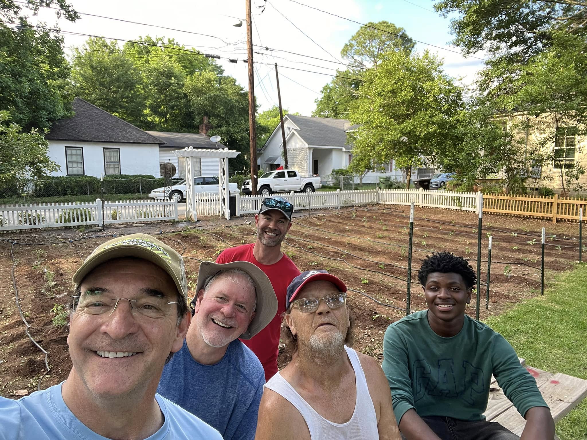 The community garden crew among planted rows