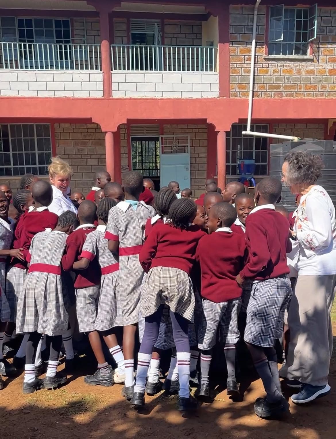 Students greeting a Grace member in the schoolyard