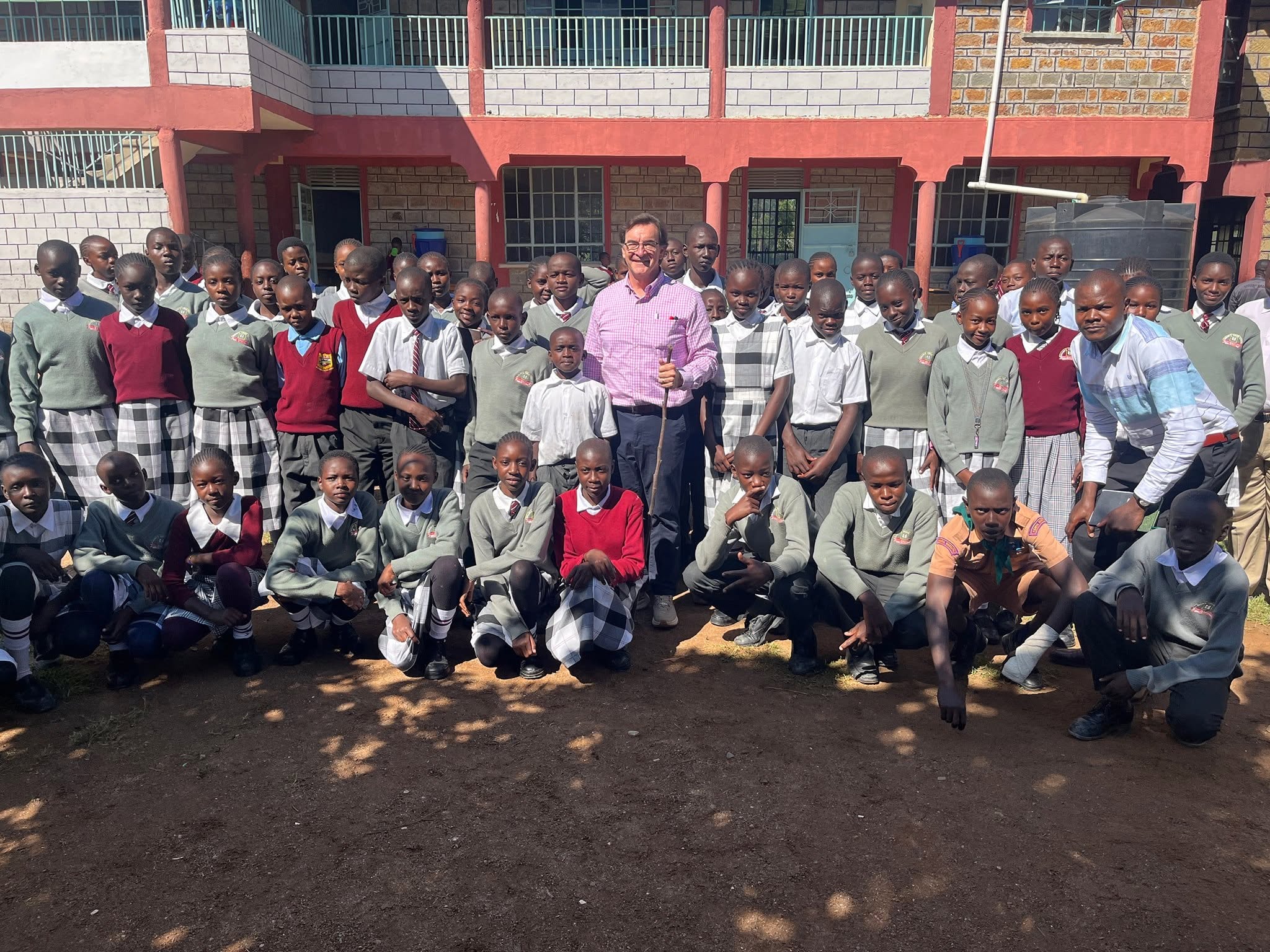 The schoolyard at Wachara, students gathered with a Grace member