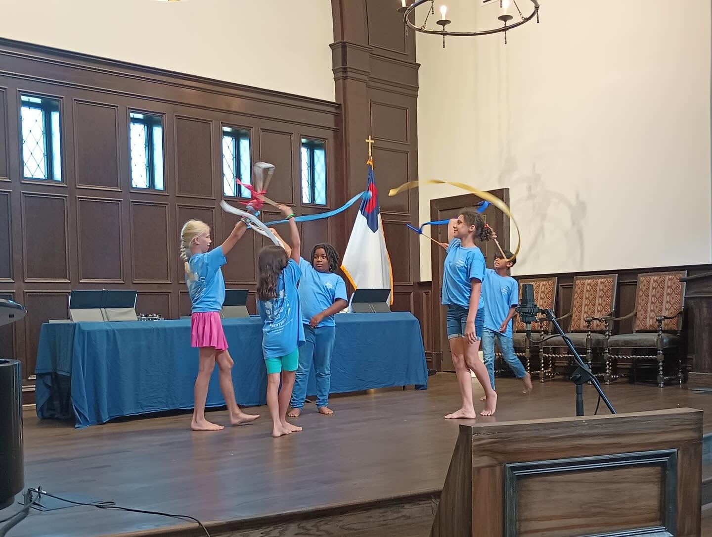 Children with ribbons and bells leading worship at arts camp